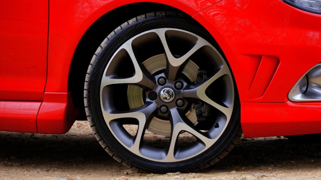 A Gray Alloy Rim on a Red Car